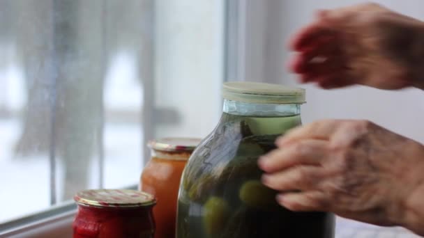 Una anciana limpia un frasco de encurtidos con su mano. — Vídeo de stock