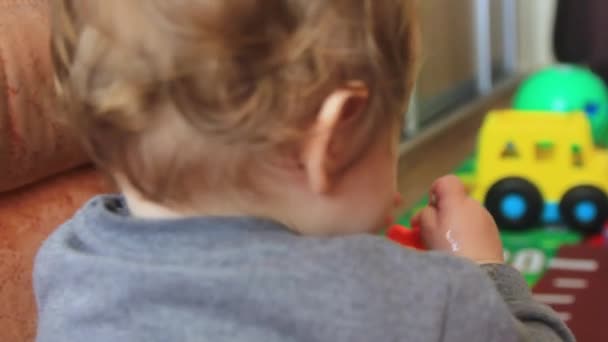 Bambino che gioca con i giocattoli, vista dal retro. — Video Stock