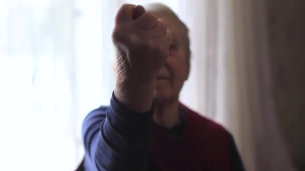 Yaşlı bir kadın müstehcen bir el hareketi yapıyor. — Stok video