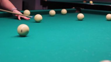 Erkek eli bilardo topunu yakın çekimde yener.