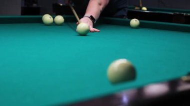 Erkek eli bilardo topunu yakın çekimde yener.