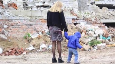 Anne ve oğlu, Rusya 'nın Ukrayna' ya büyük çaplı işgali sırasında yıkılmış bir evin yakınında..