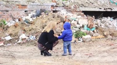 Anne ve oğlu, Rusya 'nın Ukrayna' ya büyük çaplı işgali sırasında yıkılmış bir evin yakınında..