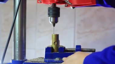 Matkap, mengeneyle tutturulmuş metal bir kilide delik açıyor..