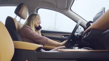 Lüks bir arabada konuşan bir iş kadını..