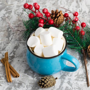 Arka planda hafif bir arka planda mavi bir fincanda nefis marşmelovlar. Kış ve Noel havası.