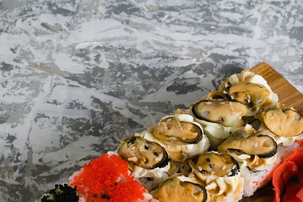 맛있는 초밥에 캐비어 와사비 간장을 곁들여 가벼운 의나무 판위에 굽는다 — 스톡 사진