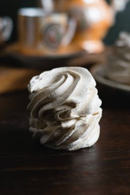 Kahverengi ahşap masada kahve doldurulmuş lezzetli beyaz marşmelov..