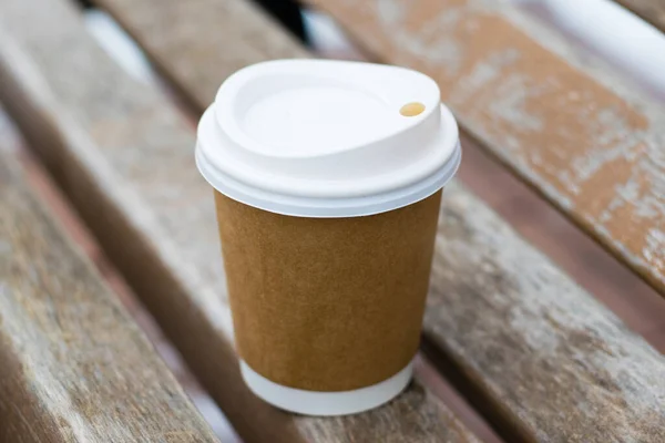 Gelas untuk kopi atau teh untuk pergi di bangku kayu cokelat di musim dingin. — Stok Foto