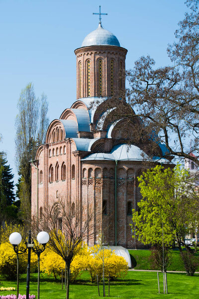 Spring architectural landscape. Church and bushes of forsythia in the center of the Ukrainian city of Chernihiv