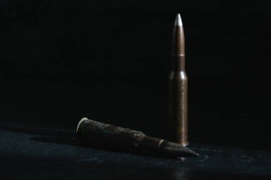 Karanlık bir arka plandaki kartuşlar, yakın plan, kopyalama alanı. Modern silahlanma ve savaş konsepti.