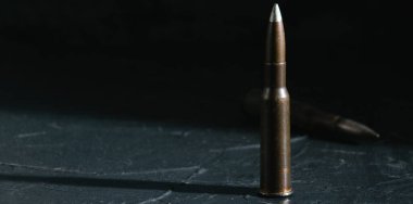 Cartridge on a dark background. The concept of modern armaments and wars.