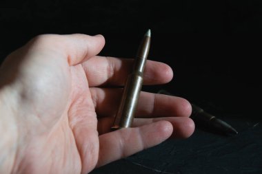 Muharebe mühimmatı koyu bir arka planda el ele veriliyor. Modern silahlanma kavramı, Ukrayna 'daki savaş ve devletin savunması.