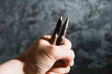 Gri bir arka planda mühimmat eli. Modern silahlanma kavramı, Ukrayna 'daki savaş ve devletin savunması..