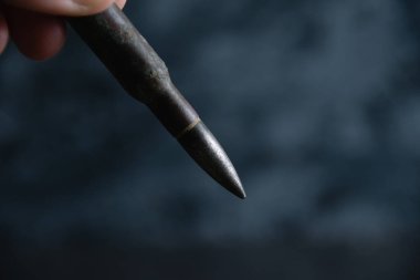 Kartuş elinde koyu gri beton arka plan, kopyalama alanı. Modern silahlanma kavramı, Ukrayna 'daki savaş ve devletin savunması..