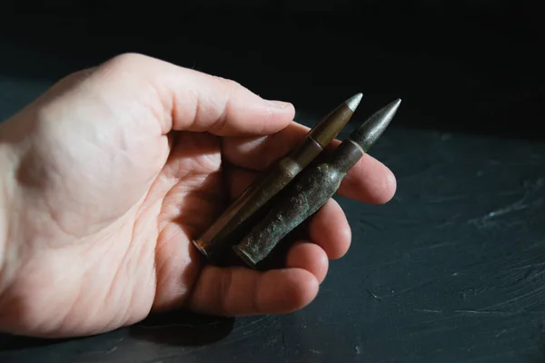 Combat ammunition close up in hand on a dark background. The concept of modern armaments, the war in Ukraine and the defense of the state. — Zdjęcie stockowe