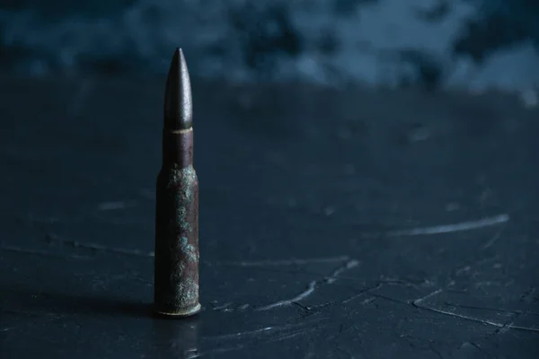 Cartridge closeup on dark gray concrete background, copy space. The concept of modern armaments, the war in Ukraine and the defense of the state. — Stockfoto