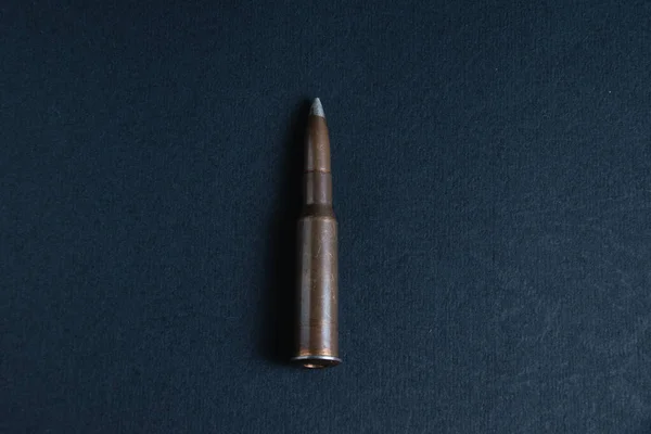 Cartridge closeup on dark gray concrete background, copy space. The concept of modern armaments, the war in Ukraine and the defense of the state. — Zdjęcie stockowe