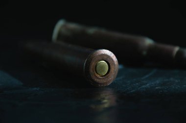 Karanlık bir arka planda cephaneli eski mermiler. Modern silahlanma ve savaş kavramı..