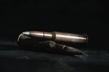 Karanlık bir arka plandaki kartuşlar, yakın plan, kopyalama alanı. Modern silahlanma ve savaş konsepti.