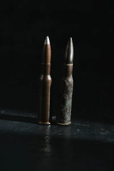 两个旧弹药筒在黑暗的背景特写 现代武器与战争的概念 — 图库照片