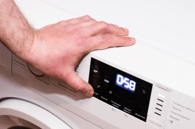 Adam çamaşır makinesini kapatır, elini kapatır..