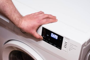 Adam çamaşır makinesini kapatır, elini kapatır..