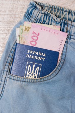 Ukrayna Hryvnia 'sı ve pasaportu kot pantolonun cebinde. Yurtdışına gitmek için hazırlık konsepti.