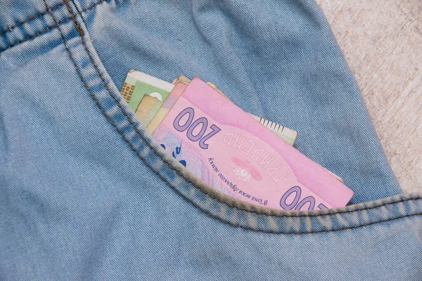 デニムパンツのポケットの中にウクライナのグリブナお金 ウクライナ人への財政援助の概念 — ストック写真