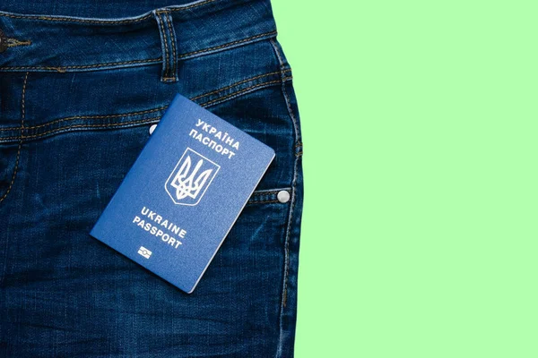 International passport and jeans isolate on green background with copy space.