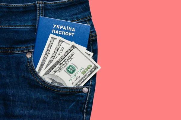 Passport and money in the pocket of denim pants isolate on a pink background with copy space. The concept of fees for travel abroad.