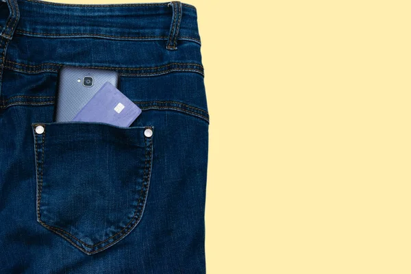 Smartphone Und Kreditkarte Jeanstasche Isoliert Auf Hellem Terrakottahintergrund — Stockfoto