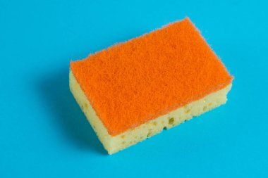 Mavi arka planı temizlemek için gözenekli sünger. Ev temizliği kavramı.