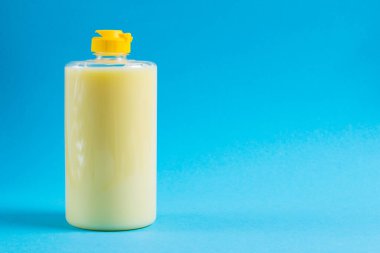 Mavi arka planda şeffaf plastik bir pakette bulaşık deterjanı. Ekolojik deterjan ve çevre koruma kavramı.