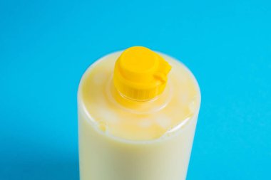 Mavi arka planda şeffaf plastik bir pakette bulaşık deterjanı. Ekolojik deterjan ve çevre koruma kavramı.