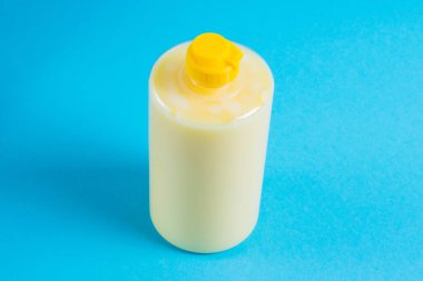 Mavi arka planda şeffaf plastik bir pakette bulaşık deterjanı. Ekolojik deterjan ve çevre koruma kavramı.