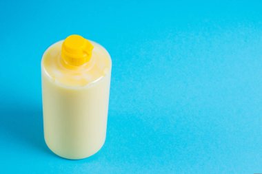 Mavi arka planda şeffaf plastik bir pakette bulaşık deterjanı. Ekolojik deterjan ve çevre koruma kavramı.