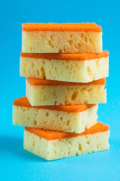 Temizlik ve bulaşıklar için süngerler kopya alanı olan mavi bir arkaplanda kapanıyor.