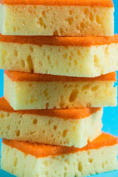 Temizlik ve bulaşıklar için süngerler kopya alanı olan mavi bir arkaplanda kapanıyor.