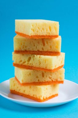 Bulaşık yıkamak ve daireyi temizlemek için süngerler mavi arka planda bir tabakta. Ev için ekolojik deterjan kullanma kavramı.