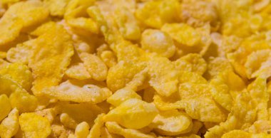 Lezzetli mısır gevrekleri, yakın çekim, kopyalama alanı olan sarı desenli yiyecek arka planı..