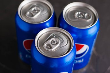 Ukrayna, Chernihiv, 23 Haziran 2022: Gri arka planda birkaç kutu soda Pepsi.