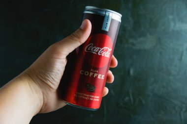 Ukrayna, Chernihiv, 23 Haziran 2022: Koyu gri arka planda bir kadının elinde kola..