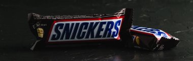 Ukrayna, Chernihiv, 23 Haziran 2022: Karanlık arka planda iki lezzetli çikolata snickers.