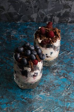 Yabanmersinli tatlılar, yoğurt, çikolata, kiraz, ahududu ve cam bardakta yulaf ezmesi..