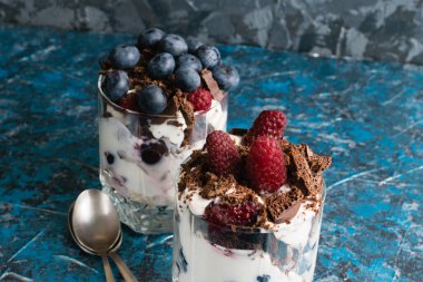 Böğürtlenli, yoğurtlu, yulaf ezmeli ve siyah gözenekli çikolatalı çok lezzetli tatlılar. Çikolata ve ahududu tatlısı. Yakın plan..