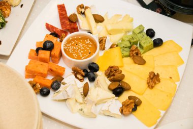 Tabaktaki farklı peynirlerden peynir dilimleri. Şenlik masasında şarap için aperatif.