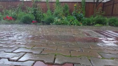 Bahçe taşı kaldırımlarına yağmur yağıyor.