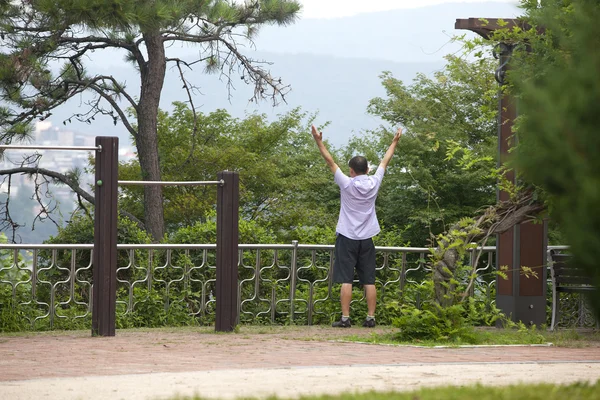L'uomo coreano si estende in un parco . — Foto Stock