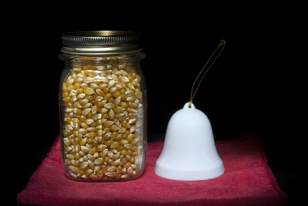 Jar of popcorn and a bell. — Stock Photo, Image